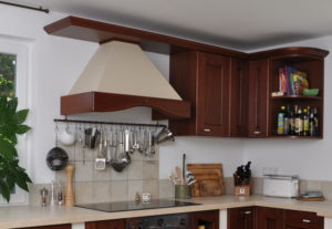 Die passende Kaminhaube gibt dieser Ducale- Küche eine elegante großzügige Note und gewährt Kopffreiheit beim großen Kochen. Eine Relingstange hält alle wichtigen Utensilien dafür bereit.