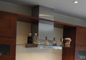 Die moderne Abzugshaube mit Glasschirm schenkt Gewürzen Platz zur übersichtlichen und griffbereiten Nutzung.